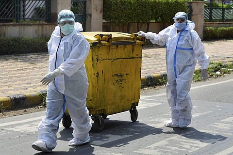 Workers in protective suits dispose COVID-19 bio-medical waste outside a hospital. (File Photo | PTI)