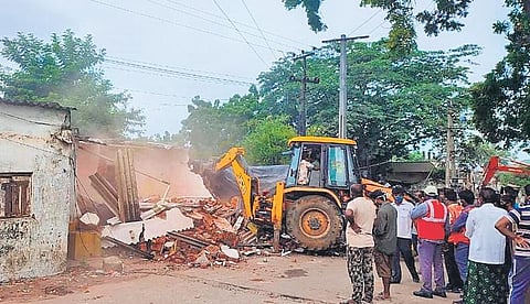 Railway and police officials demolish houses illegally constructed on Railway land at Medarabasti area in Kothagudem town on Tuesday. (Photo | Express)