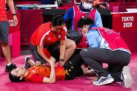 Singapore's Yu Mengyu receives medical treatment during her table tennis women's singles semifinal match against China's Chen Meng. (Photo | AP)