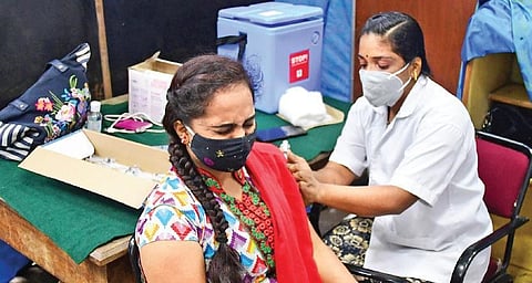 A health worker administers Covid-19 vaccine to a student at the Government Arts College  in Bengaluru on Wednesday. (Shriram BN, EPS)