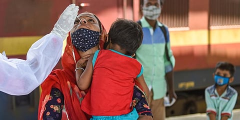 A BMC health worker collects swab sample of a passenger for COVID-19 test, at a station in Mumbai (Photo | PTI)
