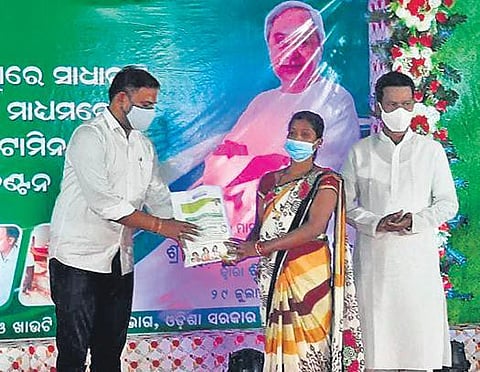 IT and Sports Minister Tusharkanti Behera distributing fortified rice to a woman  in Malkangiri on Thursday | Express