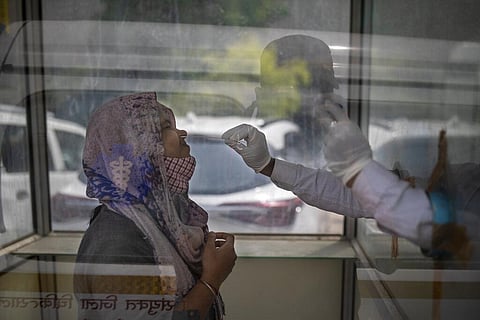 A health worker takes a swab sample to test for COVID-19 at a government hospital in Noida. (Photo | AP)