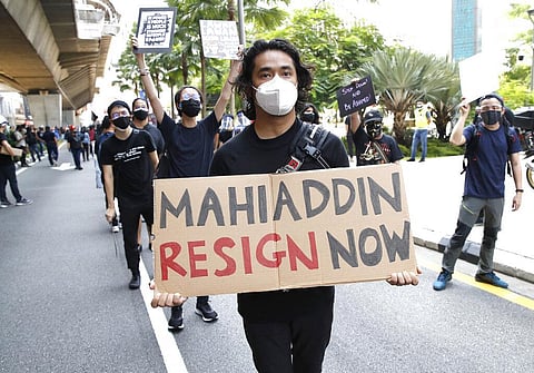 A protester holds placard during a demonstration demanding the prime minister step down near the Independence Square in Kuala Lumpur. (Photo | AP)