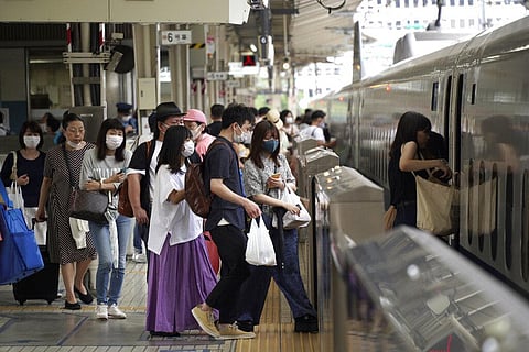 Passengers wearing face masks to help curb the spread of the coronavirus get on board a west-bound bullet train at Tokyo Station. (Photo | AP)