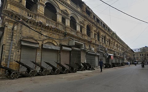 A private security guard walks through a market closed due to new restrictions announced by provincial government to help control Covid-19. (Photo | AP)
