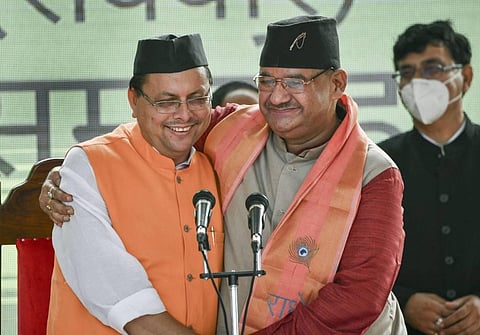 Uttarakhand new Chief Minister Pushkar Singh Dhami (L) and BJP MLA Ganesh Joshi (R) after taking oath during a swearing-in ceremony in Dehradun. (Photo | PTI)