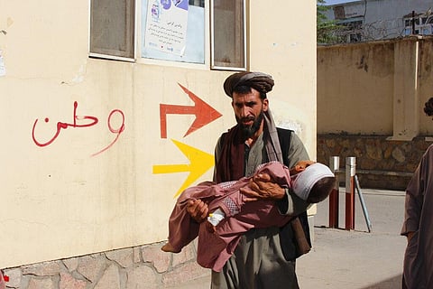 An Afghan civilian carry a wounded child to the hospital after he was injured during fighting between Taliban and government in Badghis province, northwest of Afghanistan, July, 7 2021. (Photo | AP)