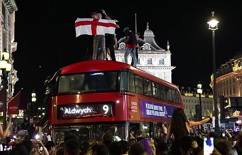 Fans celebrate on top of a bus in central London after England won the Euro 2020 soccer championship semifinal match between England and Denmark played at Wembley Stadium. (Photo | AP)