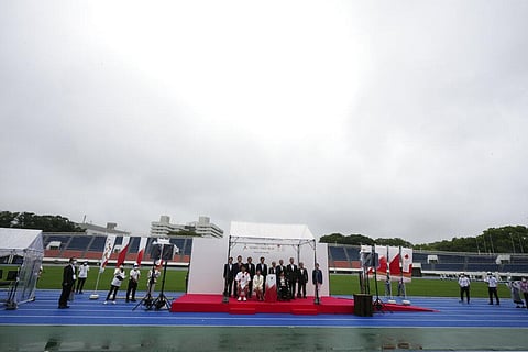 Guests pose for photographers during the unveiling ceremony for Olympic Flame of the Tokyo 2020 Olympic torch relay at empty Komazawa Olympic Park. (Photo | AP)