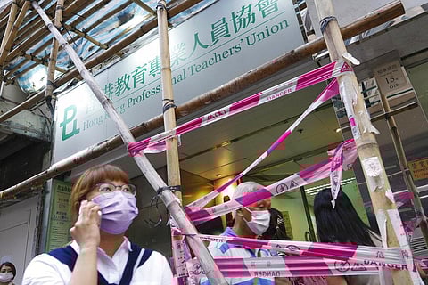People walk past the entrance of the Hong Kong Professional Teachers' Union in Hong Kong, Tuesday, Aug. 10, 2021. (Photo | AP)