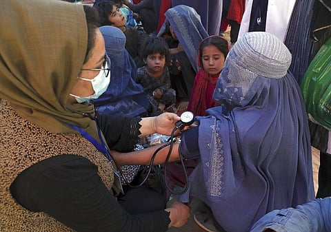 An internally displaced woman from northern provinces, has her blood pressure taken after taking refuge in a public park in Kabul, Afghanistan. (Photo | AP)