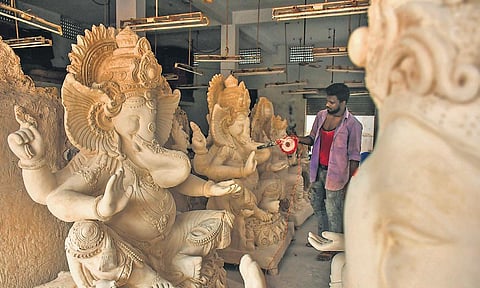An artisan works on idols of Lord Ganesha made last year at his workshop in Nunna near Vijayawada on Tuesday. (Photo I Prasant Madugula, EPS)