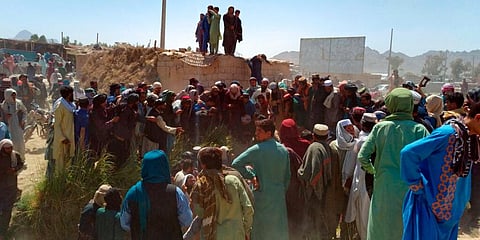Taliban fighters and Afghans gather around the body of a member of the security forces who was killed, in Farah city, capital of Farah province, southwest Afghanistan, Aug. 11, 2021. (Photo | AP)