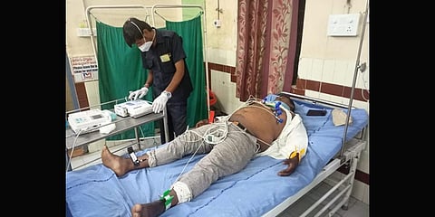 The security guard with patient B Bhaskar, at Jangaon District Government Hospital.