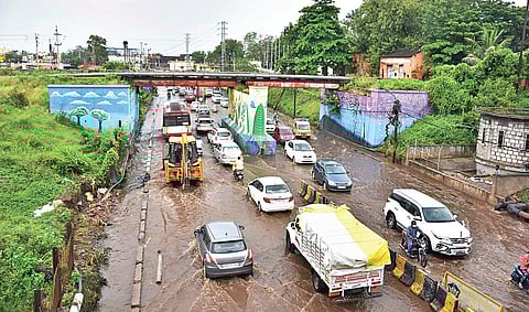 Vehicles go past railway bridge splashing rainwater (Photo | P Ravindra Babu)