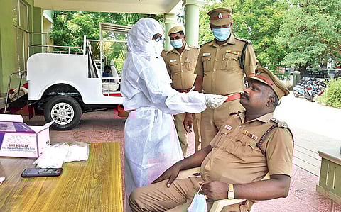 A health worker collects swab samples from a policeman at Egmore Rajarathinam Stadium in Chennai on Thursday | Ashwin Prasath