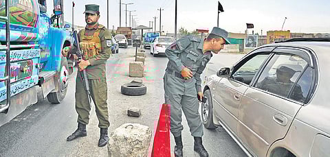 Afghan policemen stand guard at a checkpoint along a road in Kabul  on Saturday | AFP