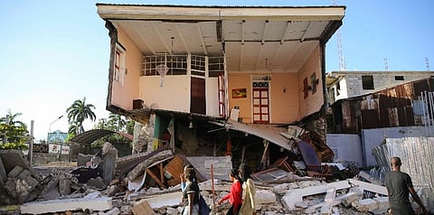 People walk past a home destroyed by the earthquake in Les Cayes, Haiti, Saturday, Aug. 14, 2021. (Photo | AP)