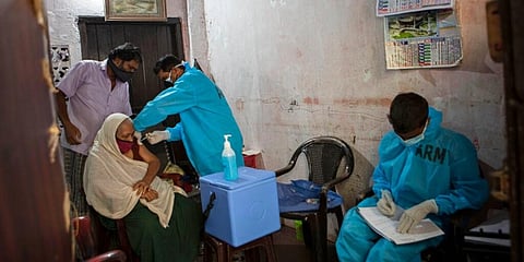 Sri Lankan army's medical corps members administer a vaccine for COVID-19 to an elderly woman in Colombo. (Photo | AP)
