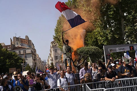 A protester waves a French flag during a demonstration in Marseille, southern France. (Photo | AP)