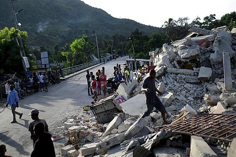 A man walks on a collapsed building in Saint-Louis-du-Sud, Haiti. (Photo | AP)