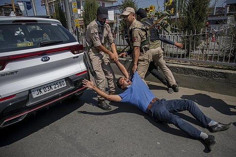 Cops detain a Kashmiri youth for participating in a religious procession in central Srinagar. (Photo | AP)