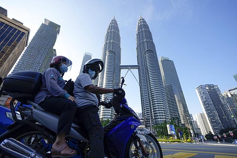 Motorists wearing face masks wait in front of the Twin Towers during the first day of Full Movement Control Order in Kuala Lumpur, Malaysia. (Photo | AP)