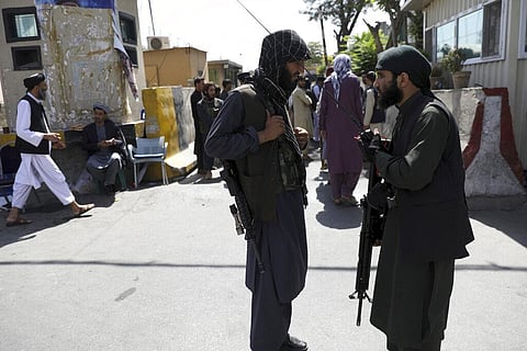 Taliban fighters stand guard in front of the main gate leading to Afghan presidential palace in Kabul, Afghanistan. (Photo | AP)