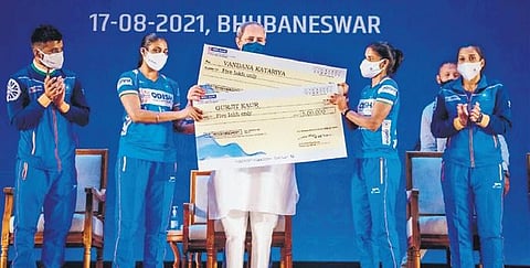 Odisha CM Naveen Patnaik (C) presenting cash awards to hockey stars.