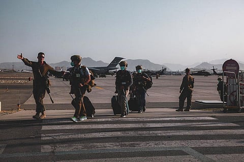 A Marine assigned to the 24th Marine Expeditionary Unit (MEU) escorts Department of State personnel to be processed for evacuation at Hamid Karzai International Airport (Photo | AP)