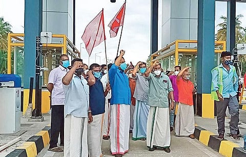 workers stage protests at the toll plaza at Thiruvallam on the NH 66 bypass stretch from Kazhakoottam to Karode on Wednesday | Express