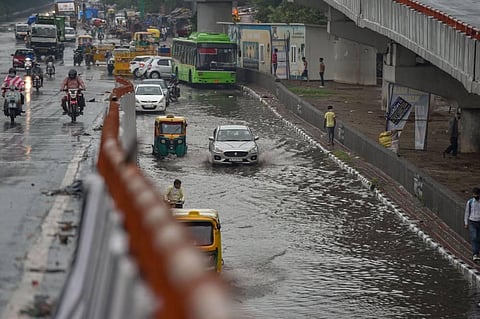 Vehicles move through a waterlogged street after heavy rain in New Delhi (File Photo | PTI)