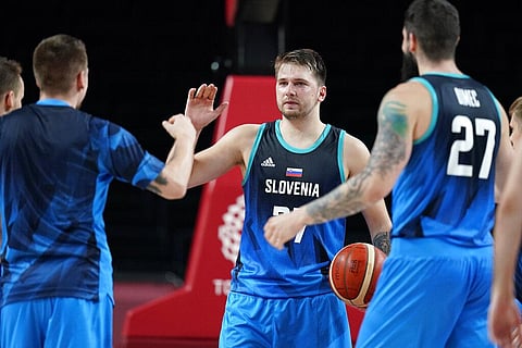 Slovenia's Luka Doncic celebrates with teammates at the end of a men's basketball preliminary round game against Spain at the 2020 Summer Olympics. (Photo | AP)
