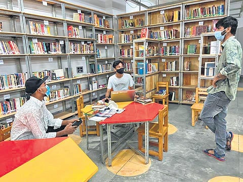 A student leader turned  librarian, a student  leader and an intern  engaged in a discussion at the Khirki library. (Photo | Express)