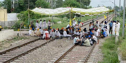 Farmers block railway tracks during their indefinite protest demanding higher sugarcane State Advisory Price (SAP), in Jalandhar. (Photo| PTI)