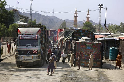 A Taliban fighter stands guard next to truck waiting to cross at a border crossing point between Pakistan and Afghanistan. (Photo | AP)