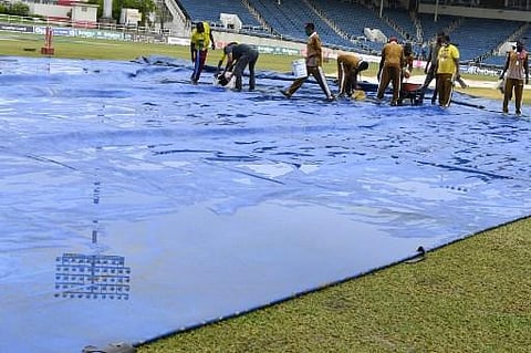 Ground staff mop up after heavy rain during day 2 of the 2nd Test between West Indies and Pakistan at Sabina Park (Photo | AFP)
