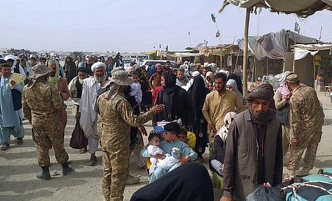Pakistan soldiers check documents of travelers crossing the border to Afghanistan through a crossing point in Chaman, Pakistan. (Photo | AP)