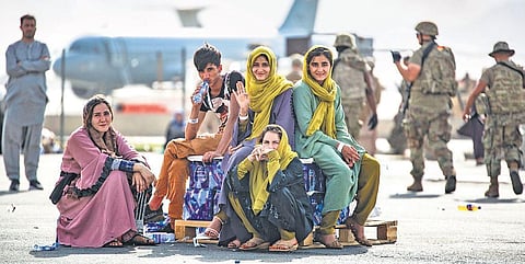 Afghan women and children at Kabul airport wait for their turn to be evacuated from Afghanistan. (Photo | AP)