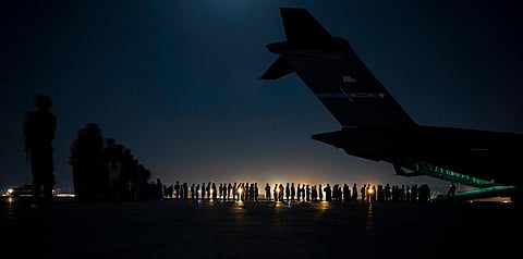 U.S. Air Force aircrew assist qualified evacuees boarding a U.S. Air Force C-17 Globemaster III aircraft in support of the Afghanistan evacuation in Kabul airport. (Photo | AP)
