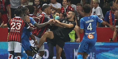 Marseille's French midfielder Dimitri Payet reacts as players from OGC Nice and Olympique de Marseille stop a fan invading the pitch trying to kick Payet during the French L1 match. (Photo| AFP)