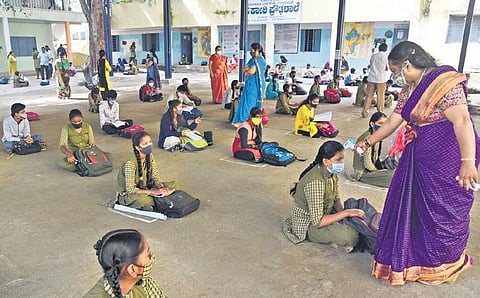 Students at a government high school get their temperature checked before classes start, in Bengaluru on Monday | VINOD KUMAR T
