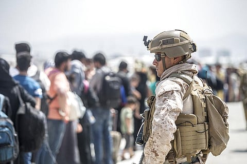 A Marine with Special Purpose Marine Air-Ground Task Force-Crisis Response-Central Command provides assistance during an evacuation at Hamid Karzai International Airport in Kabul | AP
