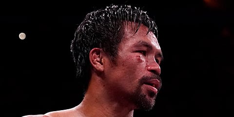 Manny Pacquiao, of the Philippines, waits in the ring with a trainer after losing his fight to Yordenis Ugas, of Cuba, in a welterweight championship boxing match in Las Vegas. (Photo | AP)