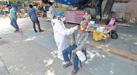 A healthcare worker collects swab sample of a man for Covid testing. (File Photo | Shekhar Yadav, EPS)