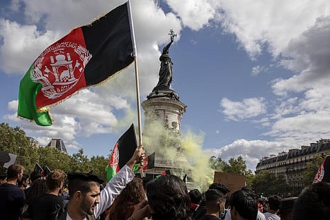 A man holds an Afghan flag during a demonstration in Paris, France, Sunday, Aug. 22, 2021. (Photo | AP)