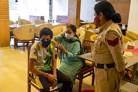 A health worker administers a vaccine for COVID-19 at a hotel lobby repurposed for a vaccination drive in Dharmsala. (Photo | AP)
