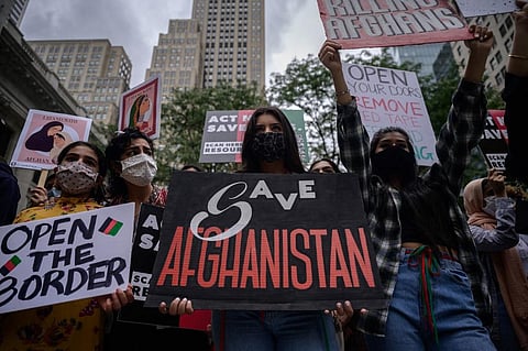 Members and supporters of New York's Afghan community hold placards and shout slogans as they attend a march and protest aiming to raise awareness of Afghanistan's refugee crisis. (Photo | AFP)