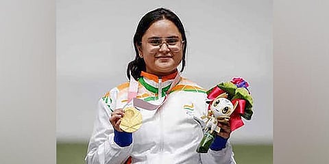 Indian sports shooter Avani Lekhara poses for photographs while standing on the podium after receiving the gold medal in womens 10m air rifle standing SH1 event at the Tokyo Paralympics. (Photo | PTI)